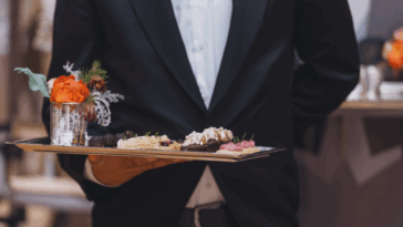 A waiter holding a tray of appetizers.
