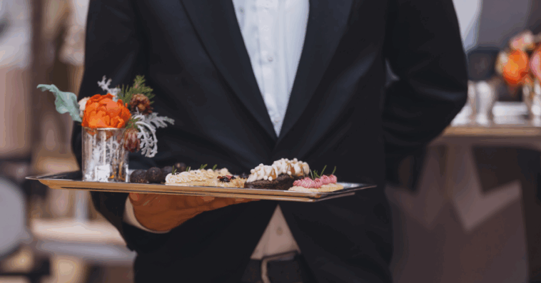 A waiter holding a tray of appetizers.