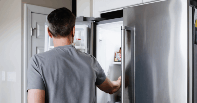 man looking in refrigerator