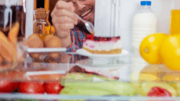 man eating out of refrigerator