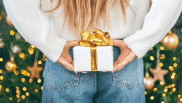 person holding wrapped gift behind their back