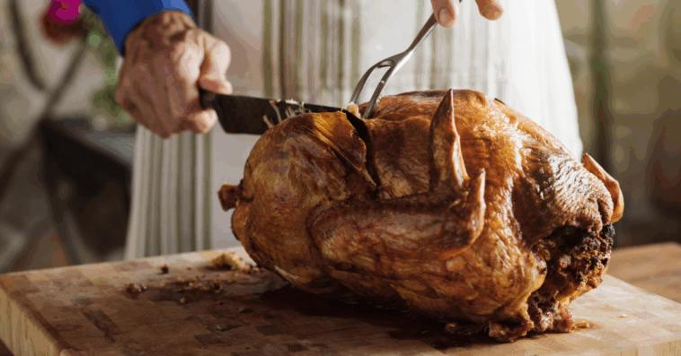 A man carving a turkey.