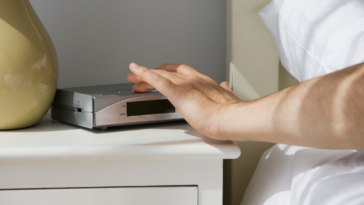 person turning off alarm clock