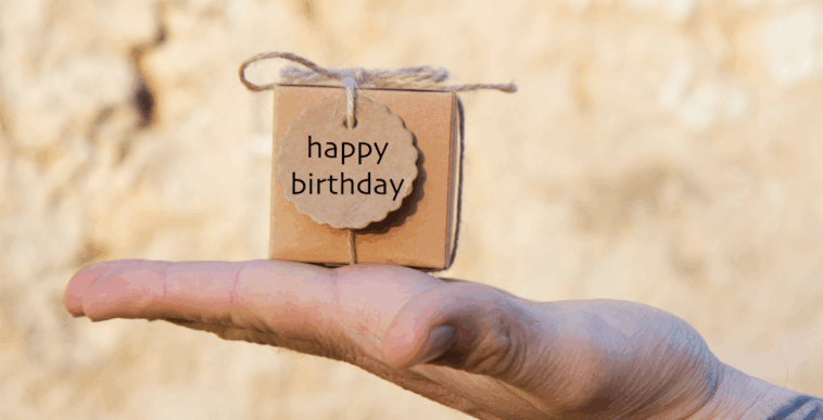 person holding small birthday gift on the palm of their hand