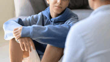 older man speaking to teen boy