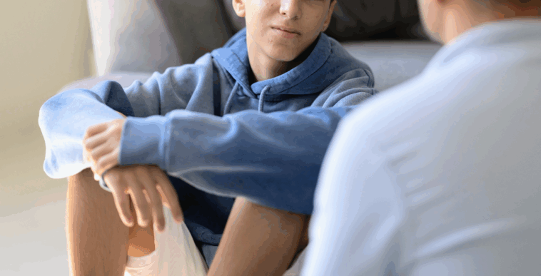 older man speaking to teen boy