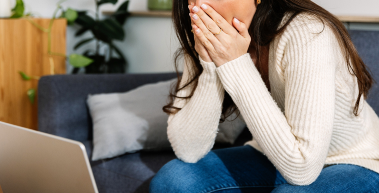 shocked young woman looking at laptop
