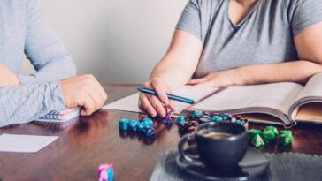 man and woman playing table top role-playing dice game