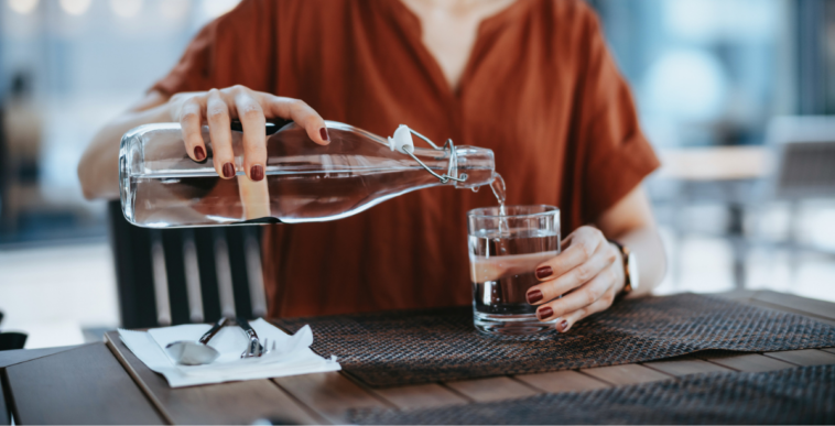A woman pouring a glass of water.