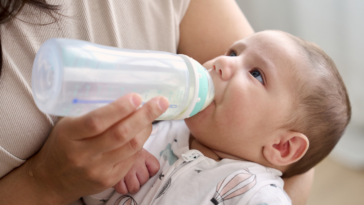 A woman feeding a baby with a bottle.