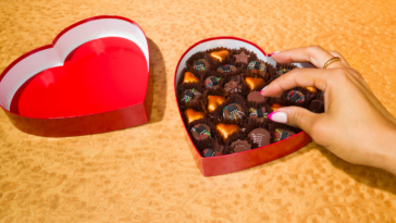 Person reaching into a box of chocolates