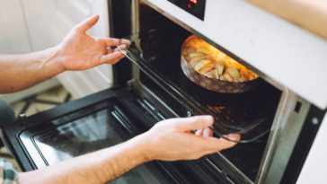 Person removing baked goods from an oven