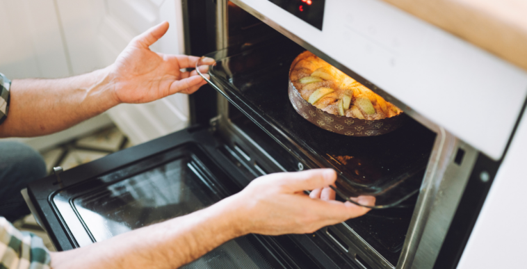 Person removing baked goods from an oven