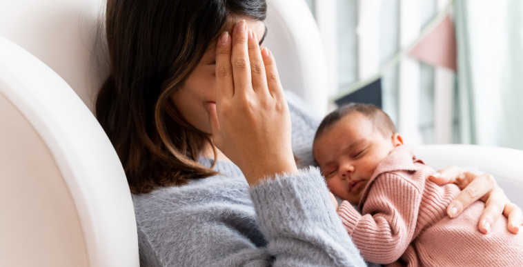 tired mother holding infant