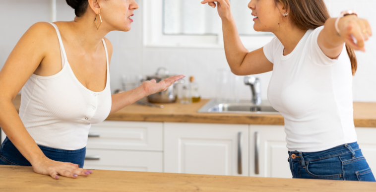 two women argue in kitchen