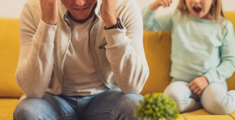 Stressed father is feeling desperate because of his screaming daughter.