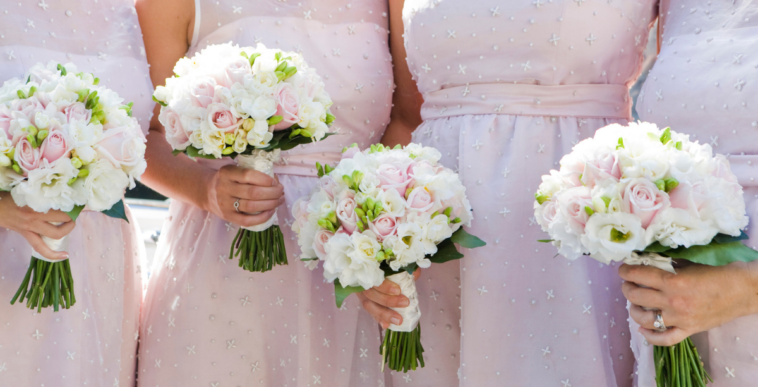 A line of bridesmaids holding bouquets.