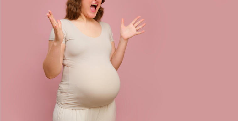 A pregnant woman emphatically holding out her arms and screaming.