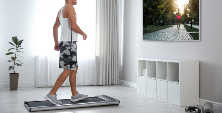 Guy in a white shirt on a walking pad in front of the television
