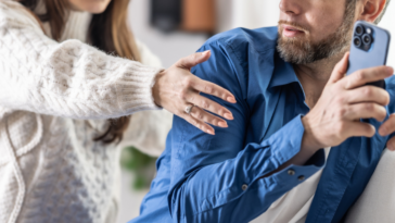 Man hiding his phone from his wife