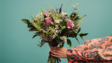 woman holding out bouquet of flowers