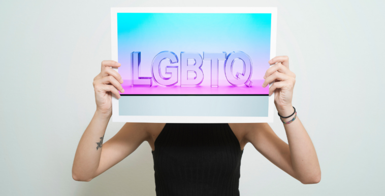 woman holding sign saying LGBTQ