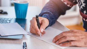 man writing thank you note