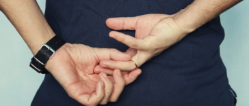 man removing wedding ring behind his back