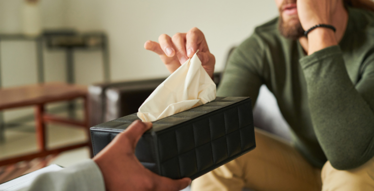 Crying person accepting tissues