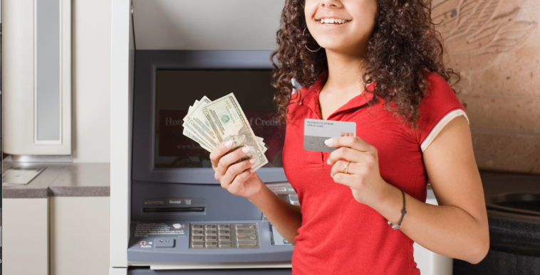 A young girl holding cash in one hand and a credit card in another.