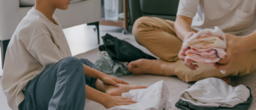 A young boy and an older man folding laundry.