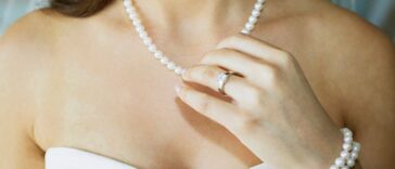 Close-up of a bride touching her pearl necklace.